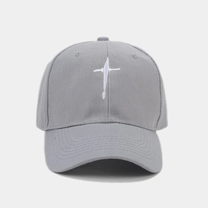 Détail de la casquette de baseball grise en coton avec broderie de croix blanche