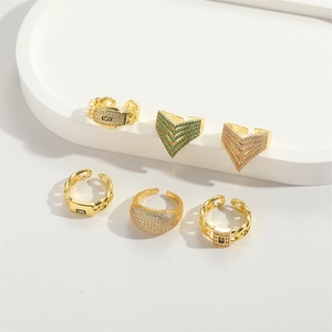 Detail of a 6-piece luxury gold ring set with V-shape, pavé zircon, and chain designs