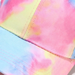 Close-up of stitching on a colorful tie-dye baseball cap with pink and blue fabric