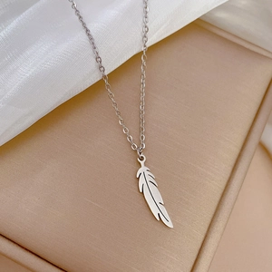Vue détaillée du collier pendentif plume argentée sur tissu en soie dans un écrin