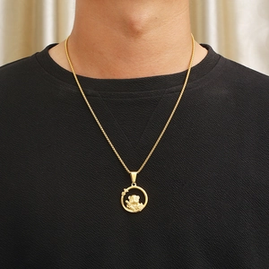 Macro view of golden panda pendant with bamboo detailing on stainless steel ring chain