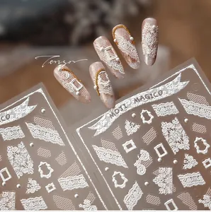 Macro shot of 5D white lace relief nail stickers with intricate floral and bow patterns