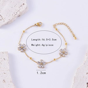 Detailed view of a gold flower bracelet with pear-shaped cubic zirconia and size dimensions