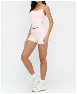 Detail of pink yoga set featuring V-cross high waist shorts and slim strap sports vest