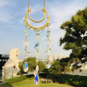 Detail of crescent moon suncatcher with blue crystal chips and teardrop prisms on gold chain