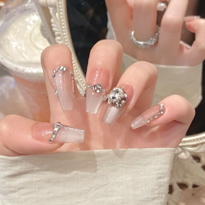 Detail of handmade press-on nails with cat-eye effect, pearls and floral crystal jewelry