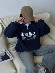 Detail of navy blue half-zip sweatshirt with white logo print on heavy cotton fabric
