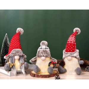 Nahaufnahme leuchtender Weihnachtswichtel mit LED-Licht in Rot und Grau gestrickt