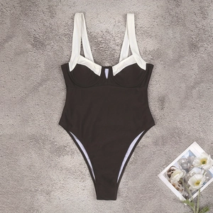 Flat lay of a one-piece swimsuit featuring black and white color block with high-cut leg