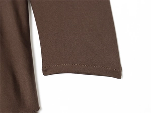 Macro view of double-stitched cuffs on a dark brown long-sleeved knitted dress