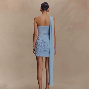 Detail view of light blue mini dress with ruched fabric and long elegant back streamers