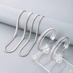 Minimalist silver stainless steel snake chain necklace and bracelet jewelry set on display