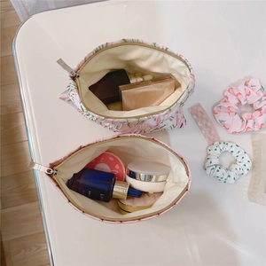 Detail view of pink floral and solid canvas cosmetic bags with metal zipper closure