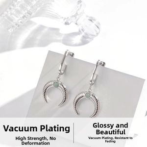 Detailed shot of silver crescent earring with green gemstone and spiral texture