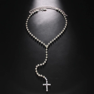 Hip hop silver cross pendant necklace with sparkling rhinestones on black background