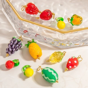 DIY colorful fruit glass pendants with gold buckles on a marble surface for jewelry making