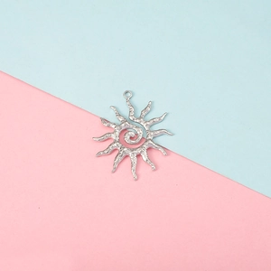 Detailed view of a silver sun-shaped pendant with wavy rays on a colorful background
