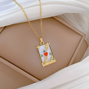 Detail of The Lovers tarot pendant necklace featuring white shell and red heart design