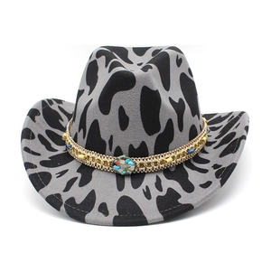 Detail of western cowboy hat with cow print felt and bohemian beaded metal chain