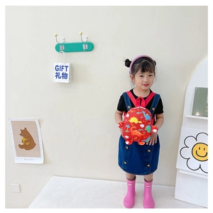 Cute red kids backpack featuring colorful dinosaur prints worn by a little girl