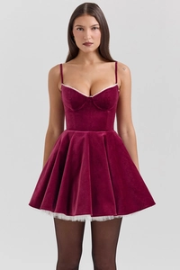 Detailed view of burgundy velvet mini dress with white lace trim and straps