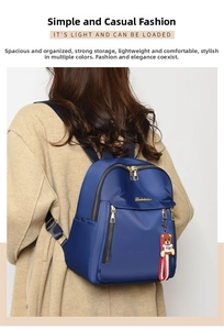 Detail view of royal blue nylon backpack with gold zippers and cute toy bear pendant