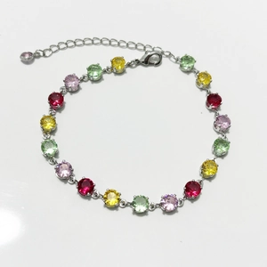 Macro detail of silver bracelet featuring multi-colored round zircon stones and lobster clasp
