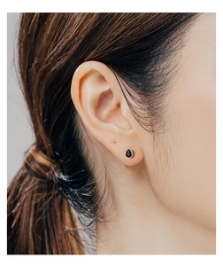 Close-up of model wearing a black teardrop-shaped stud earring in S999 silver