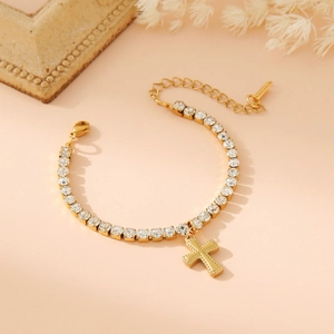 Gold-tone tennis bracelet with sparkling square stones and a hanging cross charm
