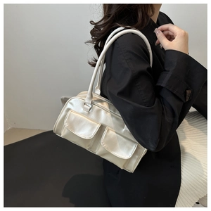 Close-up of cream square shoulder bag with double front flap pockets and silky finish