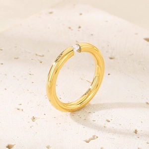 Macro view of 18k gold plated titanium steel ring with single sparkling zircon inlay