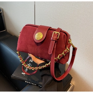 Detail of burgundy frosted leather doctor bag with gold horse emblem lock and chain