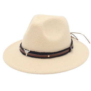 Detail of beige felt fedora hat featuring a bull skull charm and studded leather band