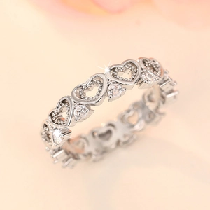 Detailed close-up of silver hollow heart-shaped ring band with sparkling zircon accents