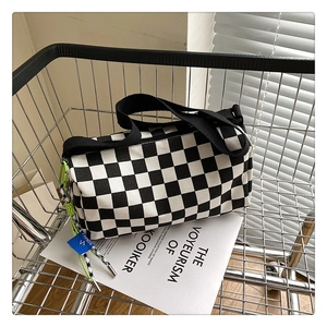 Detail of checkered crossbody bag with neon zipper and SORAKA tag in a shopping cart