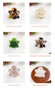 Detail showing acetate flower hair claws in cream, tortoiseshell, green, and lilac colors