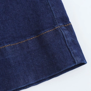 Gros plan de l'ourlet en denim bleu foncé avec coutures doubles jaunes de haute qualité