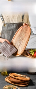 Close-up of stacking oval wooden trays showing smooth grain and water-resistant surface