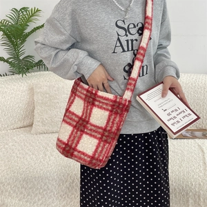Detail of red and white checkered plush bucket bag in soft faux shearling material