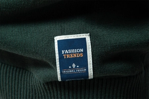Detail of the high-quality knit texture and fashion trends woven label on green sweater