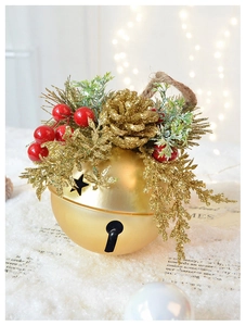 Macro shot of matte gold Christmas bell with glitter pine cones and star cutouts