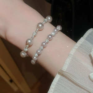 Détail de bracelets en perles superposés avec entretoises en strass étincelants sur un poignet