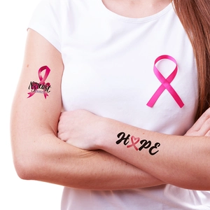 Breast Cancer Awareness temporary tattoos featuring pink ribbon and Hope on woman's arm