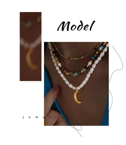 Detail of layered jewelry set with gold moon pendant and freshwater pearl necklaces