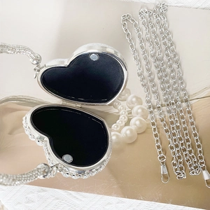 Detail of open silver heart clutch with sparkling rhinestones and black interior lining