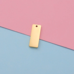 Close-up of golden rectangular stainless steel pendant with hole on split background
