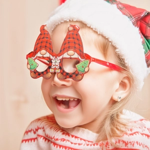 Gros plan d'un enfant portant des lunettes Père Noël à carreaux rouges pour fête de Noël