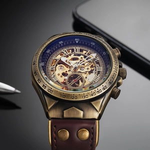 Macro shot of bronze mechanical watch with skeleton dial and brown leather rivet strap
