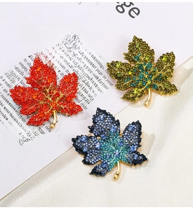 Detailed macro view of maple leaf brooches with multicolor gradient rhinestones