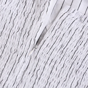 Macro detail of white striped smocked fabric texture with a hidden zipper closure
